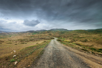 乌云山峦沥青路摄影图