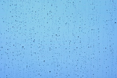阵雨后的雨滴滴落在玻璃上