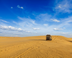 蓝天下正在沙漠中行驶的车