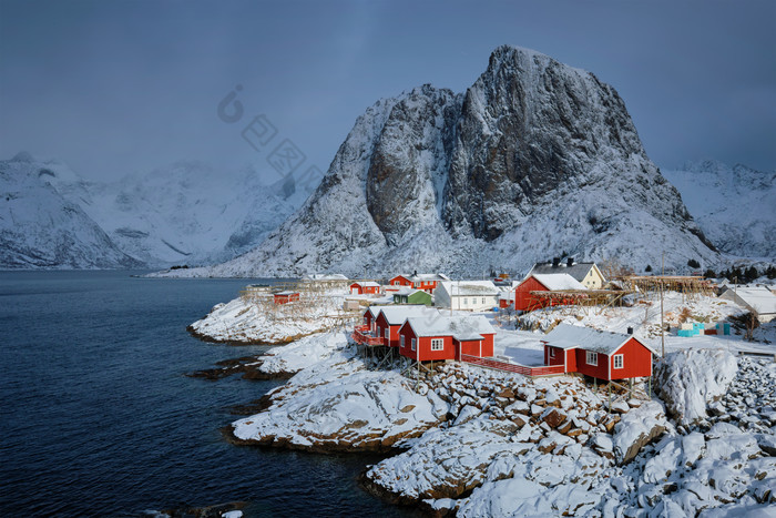 雪山湖泊旁的红色建筑物