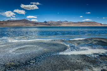 喜马拉雅山下清澈的湖水摄影图