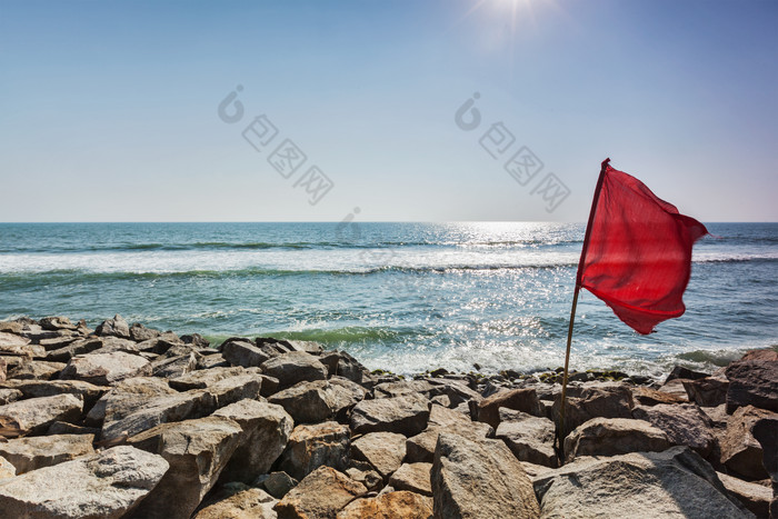 海岸岩石中的红色旗子