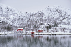 挪威岛屿雪山下的红色建筑物