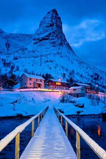 冬季湖泊上通往村庄的小桥