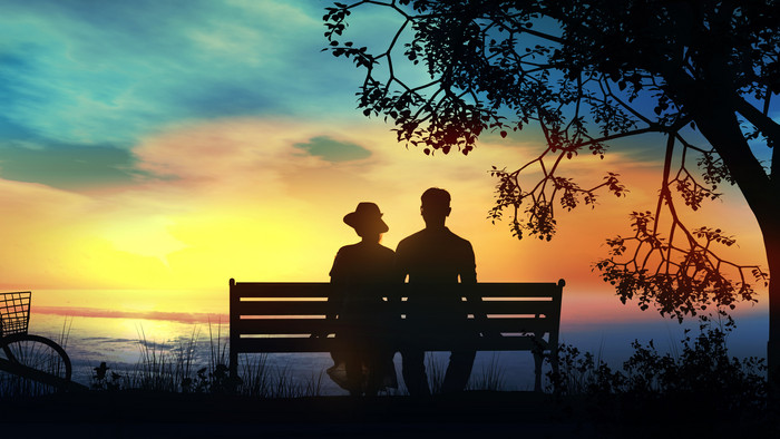 爱情情人坐在长椅上的剪影摄影图片
