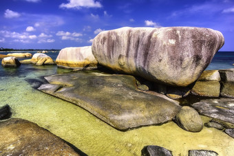 蓝天下海滩细砾云彩岩石摄影图