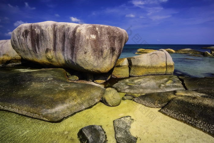 海滩细砾海岸边上的岩石摄影图
