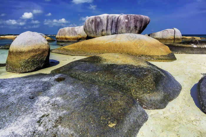 蓝天下海滩细砾岩石摄影图