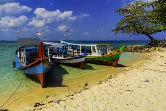 海滩细砾海边渔船停泊摄影图