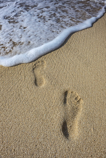 海滩上的浪花脚印摄影图