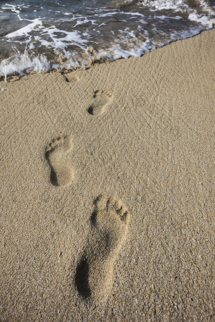 独自一人沙滩上的足迹摄影图