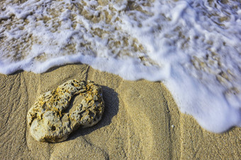 浪花<strong>沙滩上</strong>的石头摄影图