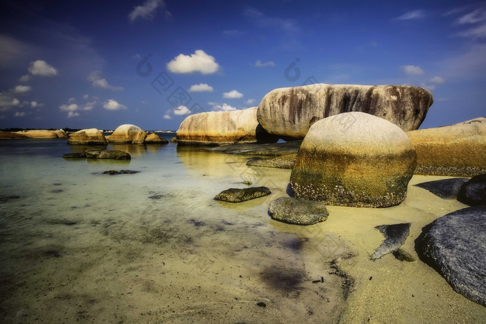 海滩沙滩海水中的岩石摄影图
