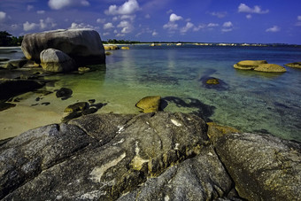 海滩上浸泡在海水中的岩石摄影图