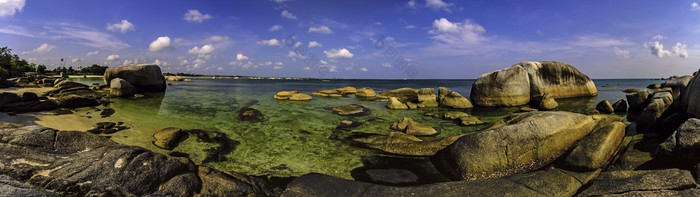 海滩沙滩下的海水岩石摄影图