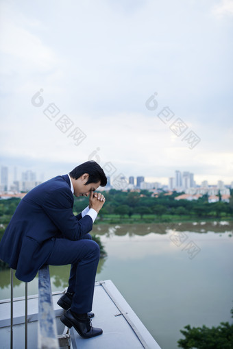 浅蓝栏杆上的男职员摄影图