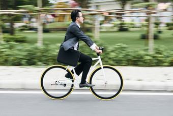绿色调骑自行车的男人摄影图
