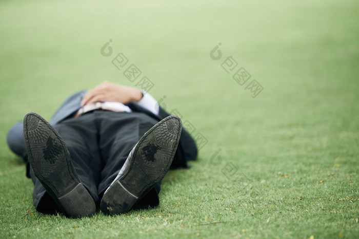 绿色调躺在草地上的男子摄影图