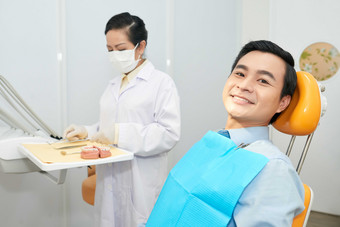 简约风做牙齿检查的男人摄影图