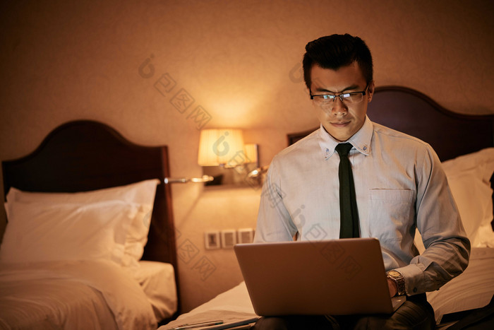 暗色调在宾馆中打电脑的男人摄影图