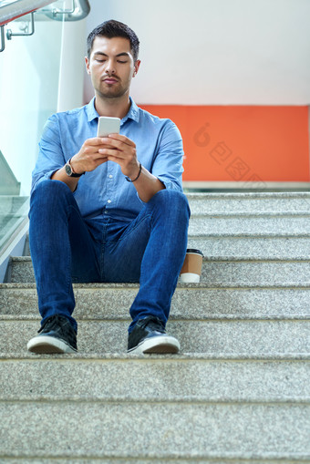 简约坐<strong>楼梯</strong>上看手机的男人摄影图