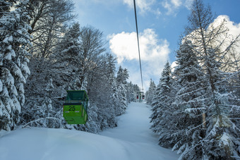 纯净的蓝天和雪地中的绿色游览车