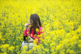 在<strong>油菜花</strong>地里采风的美女