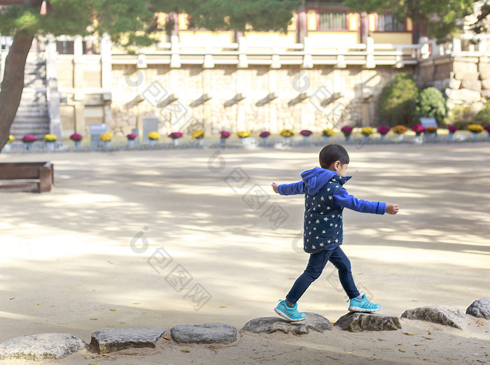 小男孩在石头上走路