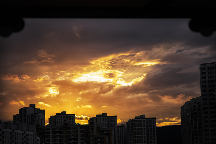 并排建筑物上面夕阳落日