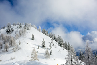 云雾散开后的蓝天和雪山山坡