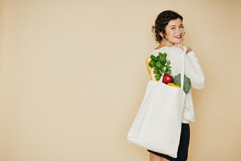 女人扛着蔬菜和<strong>购物袋</strong>