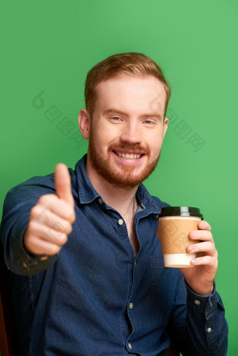 拿着咖啡竖起大拇指的男人