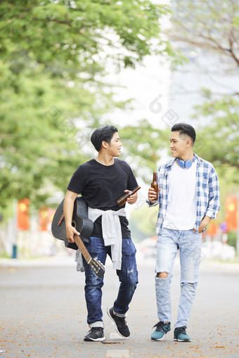 在校园里喝啤酒散步的男生