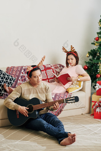 圣诞节在家弹吉他过节的夫妻