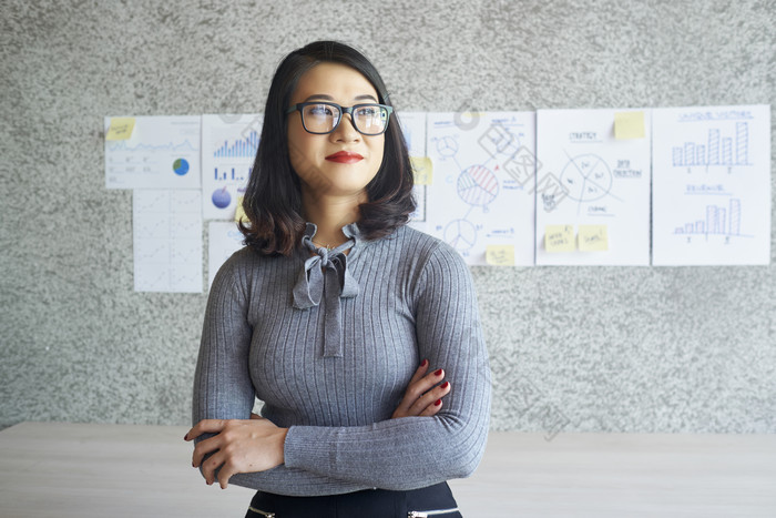 年轻女人双手抱臂看向窗外