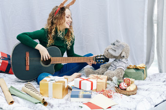 圣诞节<strong>弹吉他</strong>的女孩摄影图