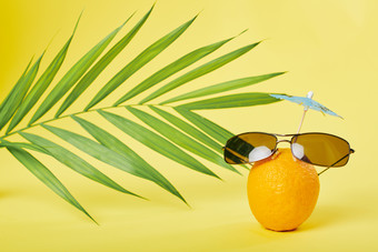 拟人化在海滩上戴太阳眼镜的橘子