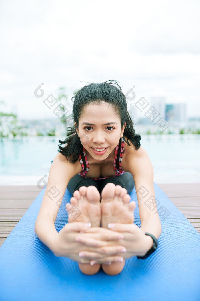 在瑜伽垫上做运动的美女正面