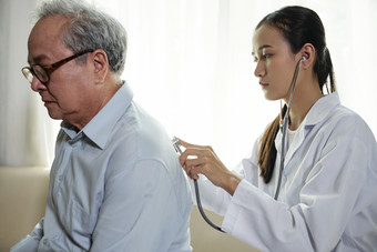 医生从病人背后用听诊器探望