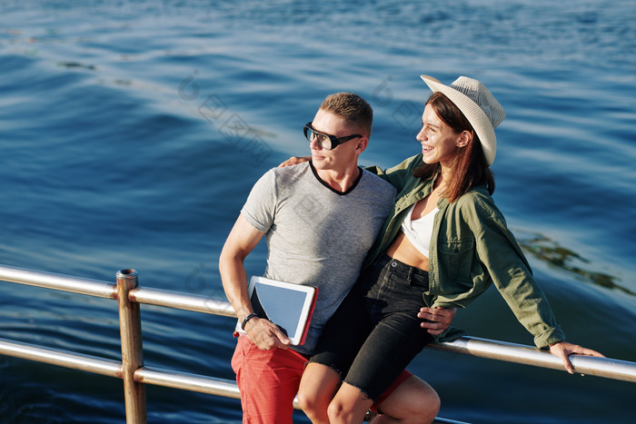 在栅栏边相拥拍照的情侣