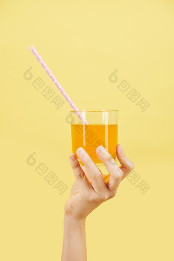 明艳背景前<strong>手举</strong>新鲜柑橘果汁