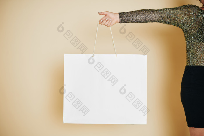 女人手提白色购物袋