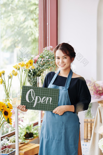 拿着open小黑板的花店老板