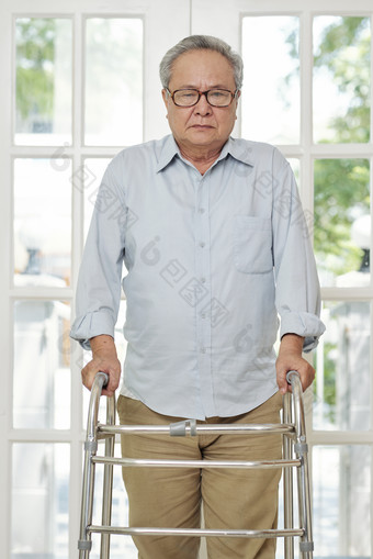 老人扶着轮椅走路