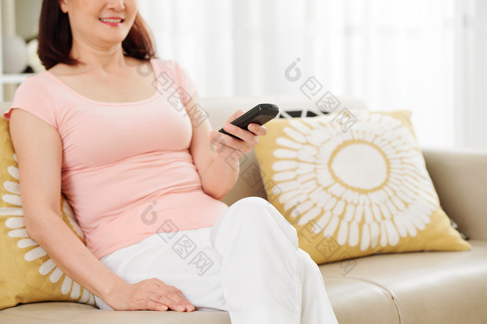 女人开心的坐在沙发上看电视