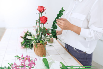 红色玫瑰鲜花花束男人整理插花年轻人摄影图