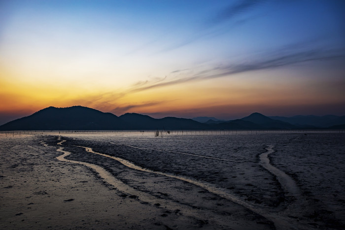 夜晚降临海上晚霞滩涂地摄影图