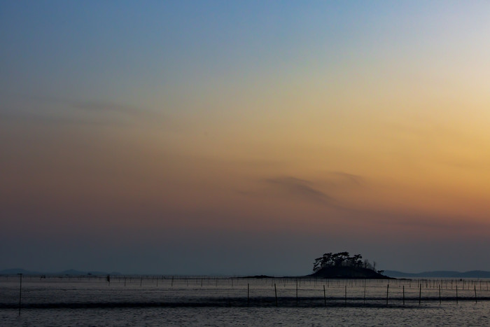晚霞海边水产养殖海岛摄影图