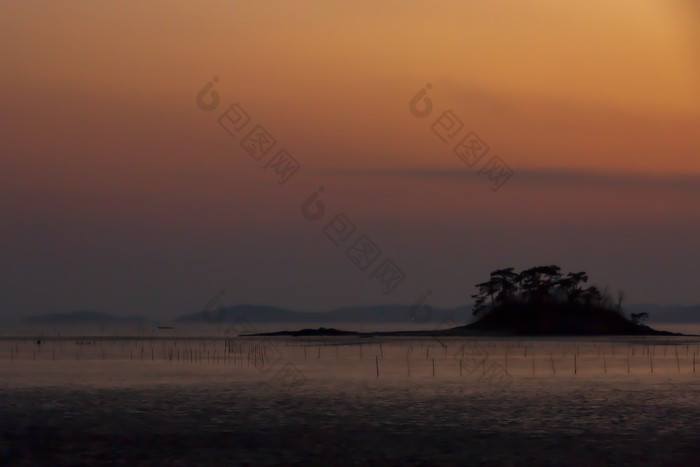 黄昏时分海边水产养殖场摄影图