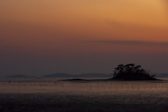 黄昏时分海边水产养殖场摄影图